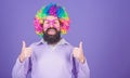 Dressed up for birthday party. Man in fashion wig gesturing thumbs up. Bearded man in clown wig hairstyle. Hipster man