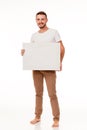 A guy with a beard posing with a white sign. Can be used for advertising, logo and business cards, contact phones, shares, etc.
