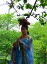 A dressed woman blowning bamboo flute