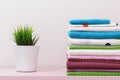 On the dresser there is a stack of clean ironed bed linen, folded multi-colored towels.