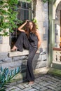 Young woman sitting outdoors by window in New York City, relaxing Royalty Free Stock Photo