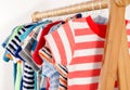 Dressing closet with clothes arranged on hangers.