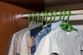 Dressing closet with complementary clothes arranged on hangers.Colorful wardrobe of newborn,kids, babies full of all clothes, shoe