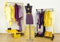 Dressing closet with complementary colors violet and yellow clothes.