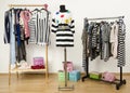 Dressing closet with striped clothes arranged on hangers.