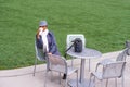 A young black woman is sitting on a chair by a green lawn, drinking coffee, taking a break Royalty Free Stock Photo