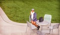 A young black woman is sitting on a chair by a green lawn, drinking coffee, taking a break Royalty Free Stock Photo