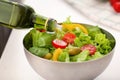 Dressing of fresh vegetable salad with olive oil, closeup Royalty Free Stock Photo