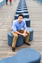 Young Man sitting on a modern style bench, relaxing and thinking Royalty Free Stock Photo