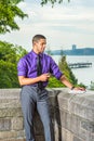 Young man standing outdoors in New York City, texting on cell phone, thinking Royalty Free Stock Photo