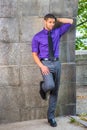 Young man standing outdoors by wall in New York City, relaxing, thinking Royalty Free Stock Photo