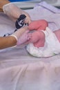 Dressing sock a newborn baby by a doctor immediately after delivery