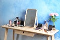 Dressing table with beauty accessories near color wall Royalty Free Stock Photo
