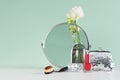 Dressing table in mint menthe with accessories for make up in silver with white flowers, round mirror, cosmetics bag, nail polish.