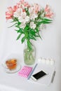 Dressing table with women`s accessories. Image of a pink gift box with a bouquet of Alstroemeria flowers, romantic candles Royalty Free Stock Photo