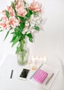 Dressing table with women`s accessories. Image of a pink gift box with a bouquet of Alstroemeria flowers, romantic candles Royalty Free Stock Photo