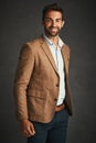 Dressing well is a form of good manners. Studio shot of a handsome young man posing against a gray background.