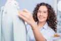 Dressmaker in blue blouse standing behind tailor`s dummy