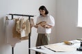 Dressmaker woman hold pattern for clothes in atelier. Fashion designer inspiring for work in studio