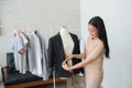 Dressmaker measuring a women suit and dress