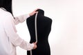 a dressmaker takes measurements from a female mannequin. isolated. tailoring is handmade. Royalty Free Stock Photo