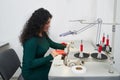 Dressmaker using professional overlock sewing machine in workshop studio. Equipment for edging, hemming or seaming Royalty Free Stock Photo