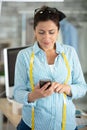 dressmaker using smartphone to send message Royalty Free Stock Photo