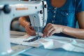 Dressmaker woman meticulously sews clothes on factory sewing machine