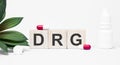 DRG the word is written on wooden cubes,plant and red pills,on white background Royalty Free Stock Photo