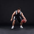 Dribbling pro. Full length shot of a male basketball player in action against a black background. Royalty Free Stock Photo
