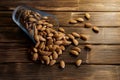 Dried almond nuts in tilted transparent blue glass on a wooden background