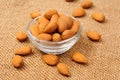 Dried almonds on glass bowl on canvas background Royalty Free Stock Photo