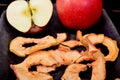 Dried apple chips and red apple on a clay dish and black background Royalty Free Stock Photo