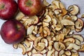 Dried Apple chips and three red apples on a white wooden table. Organic natural food. Top view. Close up Royalty Free Stock Photo