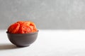 Dried apricots in a brown clay bowl on a gray table. Copy space. Front view