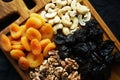 Dried fruits and nuts on a wooden board on a dark background Royalty Free Stock Photo