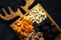 Dried fruits and nuts on a wooden board on a dark background Royalty Free Stock Photo