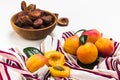 Dried apricots in the wooden bowl, fresh leaves and fruits on tablecloth on white background. Natural, organic dried apricot fruit Royalty Free Stock Photo