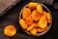 Dried apricots in a wooden plate on a dark background. Dry fruits on the kitchen table in retro style. View from above Royalty Free Stock Photo