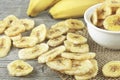 Dried banana slices and fresh bananas on wooden table. Banana chips. Banana dessert Royalty Free Stock Photo