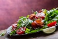 Dried beef bresaola. Salad bresaola arugula baby spinach tomatoes lime and cheese parmesan