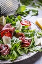 Dried beef bresaola. Salad bresaola arugula baby spinach tomatoes lime and cheese parmesan