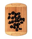 Dried black plums on a wooden board. Isolated on white background. Top view Royalty Free Stock Photo