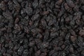 .Dried black raisins in a copper bowl, scatchered raisins around a copper bowl of raisins Royalty Free Stock Photo