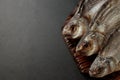 Dried bream fish on a cutting board on a black background