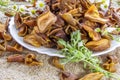 Dried brown pear slices white plate with white flowers. White daisy flowers and a green wormwood branch. Useful dry food. Edible s