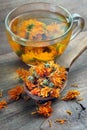 Dried calendula flowers in a wooden spoon. calendula tea. alternative medicine Royalty Free Stock Photo