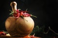 Dried chili pepper and ground in wooden mortar, black kithen table, selective focus Royalty Free Stock Photo