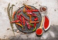 Dried chili peppers on a tray with crushed red pepper in the cups, with herbs. Royalty Free Stock Photo