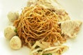 Dried Chinese yellow egg noodles topping slice boiled  pork and meatball dressing black sweet soybean sauce on dish with soup Royalty Free Stock Photo